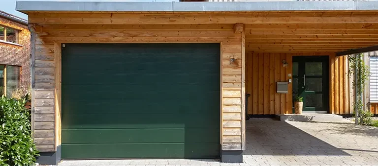 Garage en bois moderne dkz avec carport et porte basculante vert foncé dans les hautes-pyrénées
