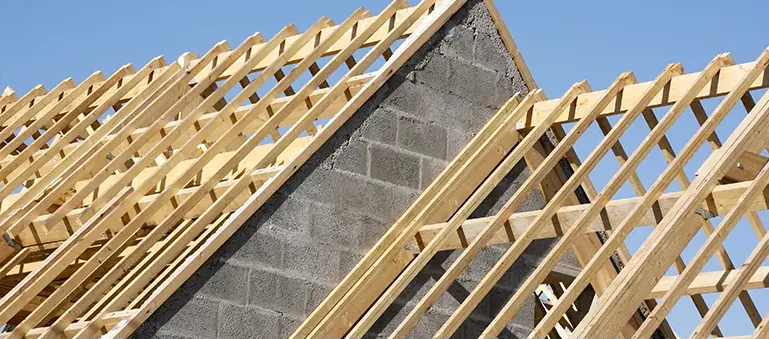 Charpente bois dkz sur murs en parpaings sous ciel bleu, chantier de toiture dans les Hautes-Pyrénées