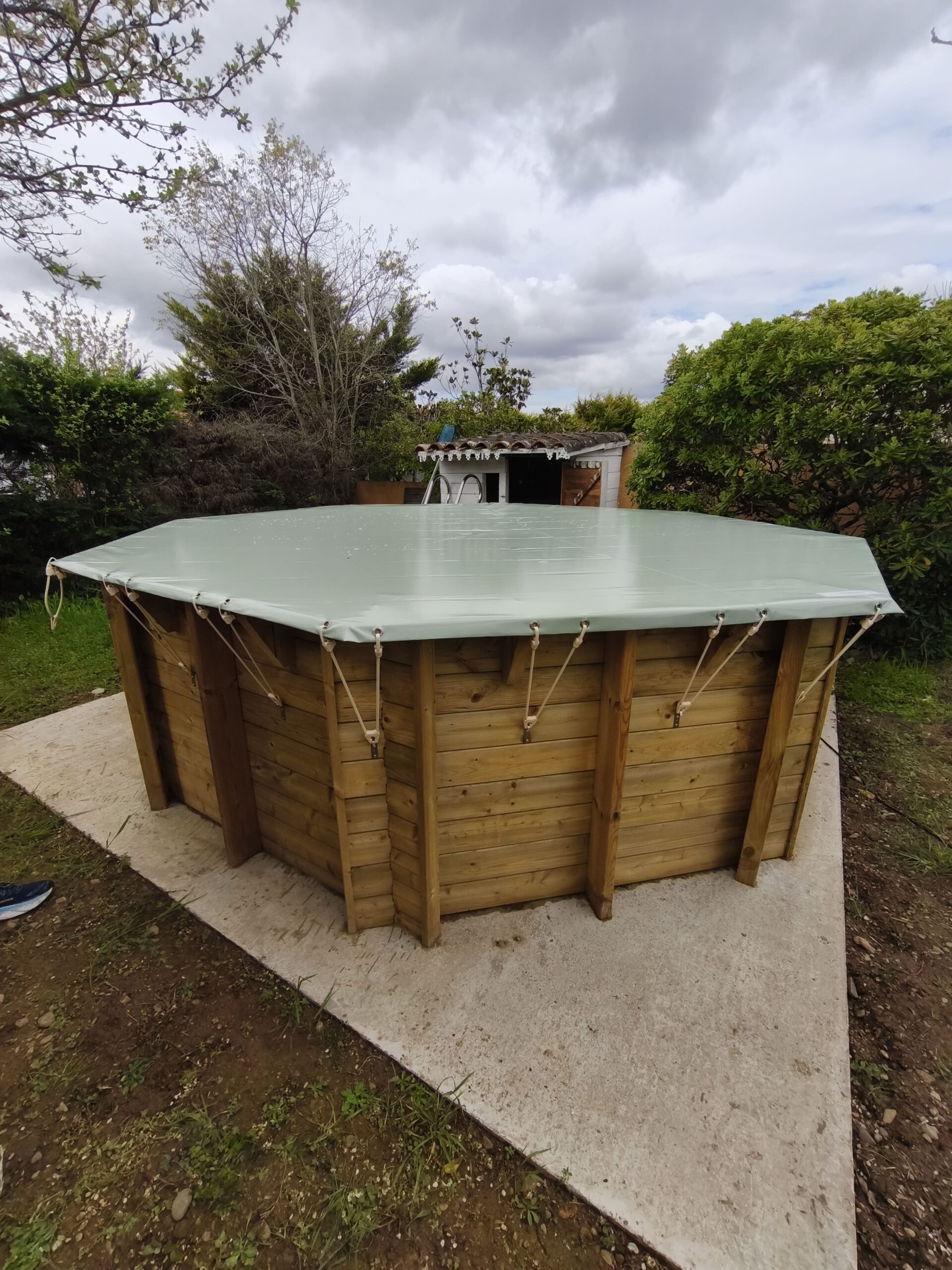 Piscine bois hors sol bâchée sur dalle béton, jardin verdoyant dkz dans les Hautes-Pyrénées
